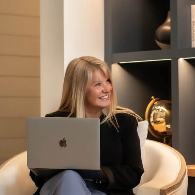 Ann of Tomegan Marketing Group working with a laptop