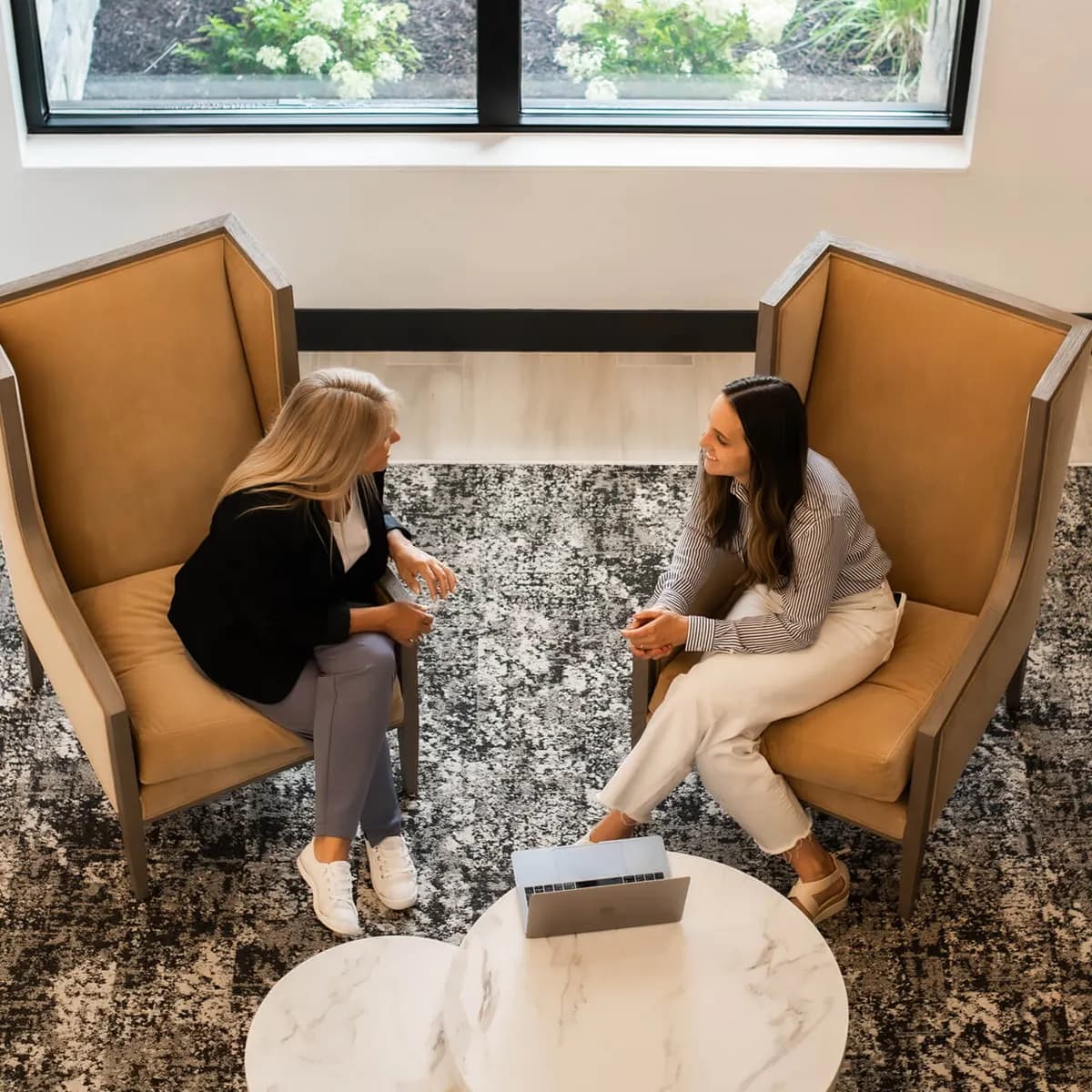 Ann and Gayle of Tomegan Marketing Group collaborating beside a laptop